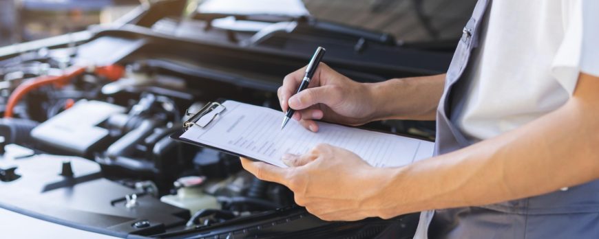 A certified technician performing a battery load test and under-hood safety check at Blizard Auto Repair.